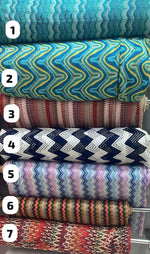 Selection of colorful zigzag knit fabric rolls for dresses and evening wear.