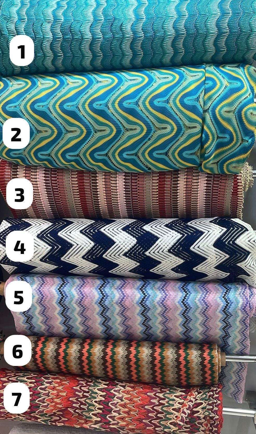 Selection of colorful zigzag knit fabric rolls for dresses and evening wear.