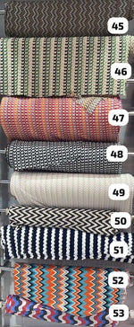 Colorful zigzag knit fabric rolls in various mesh designs for dressmaking and sewing projects