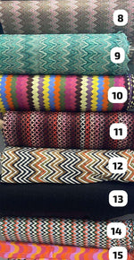 Various colorful zigzag knit fabric rolls with different patterns and textures arranged in a stack labeled 8 to 15
