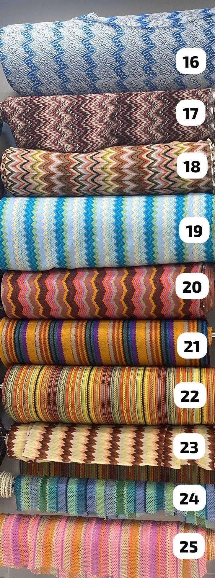Stack of various zigzag knit mesh fabrics in multiple colors and patterns for evening wear and casual garments