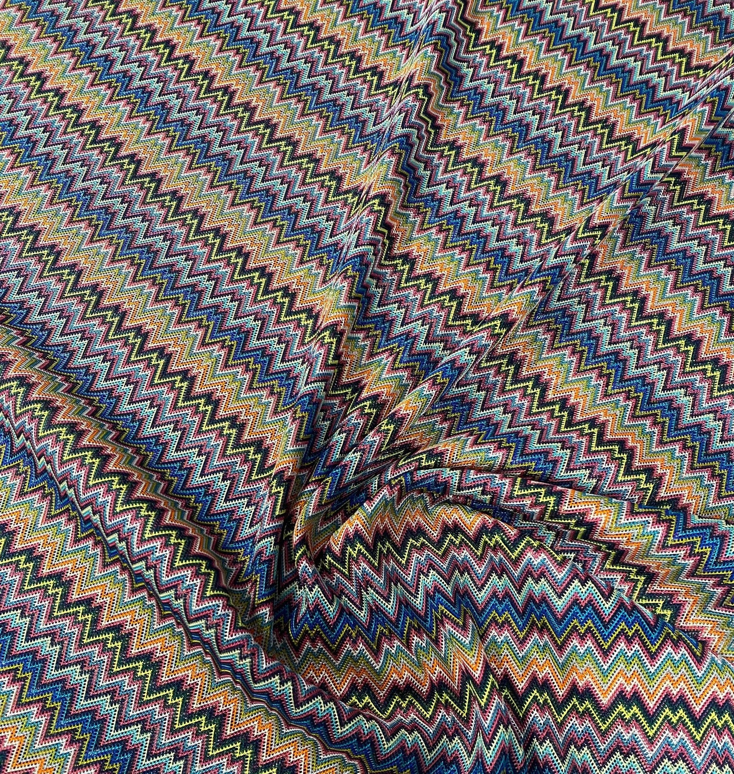 Colorful zigzag knitted mesh fabric with vibrant multicolor pattern and lightweight breathable texture for creative projects