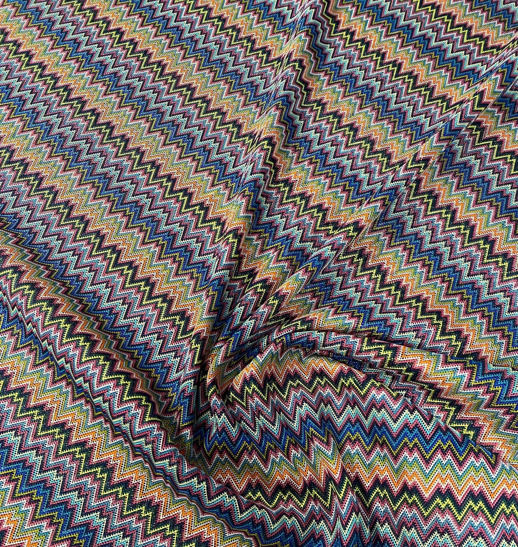 Colorful zigzag knitted mesh fabric with vibrant multicolor pattern and lightweight breathable texture for creative projects