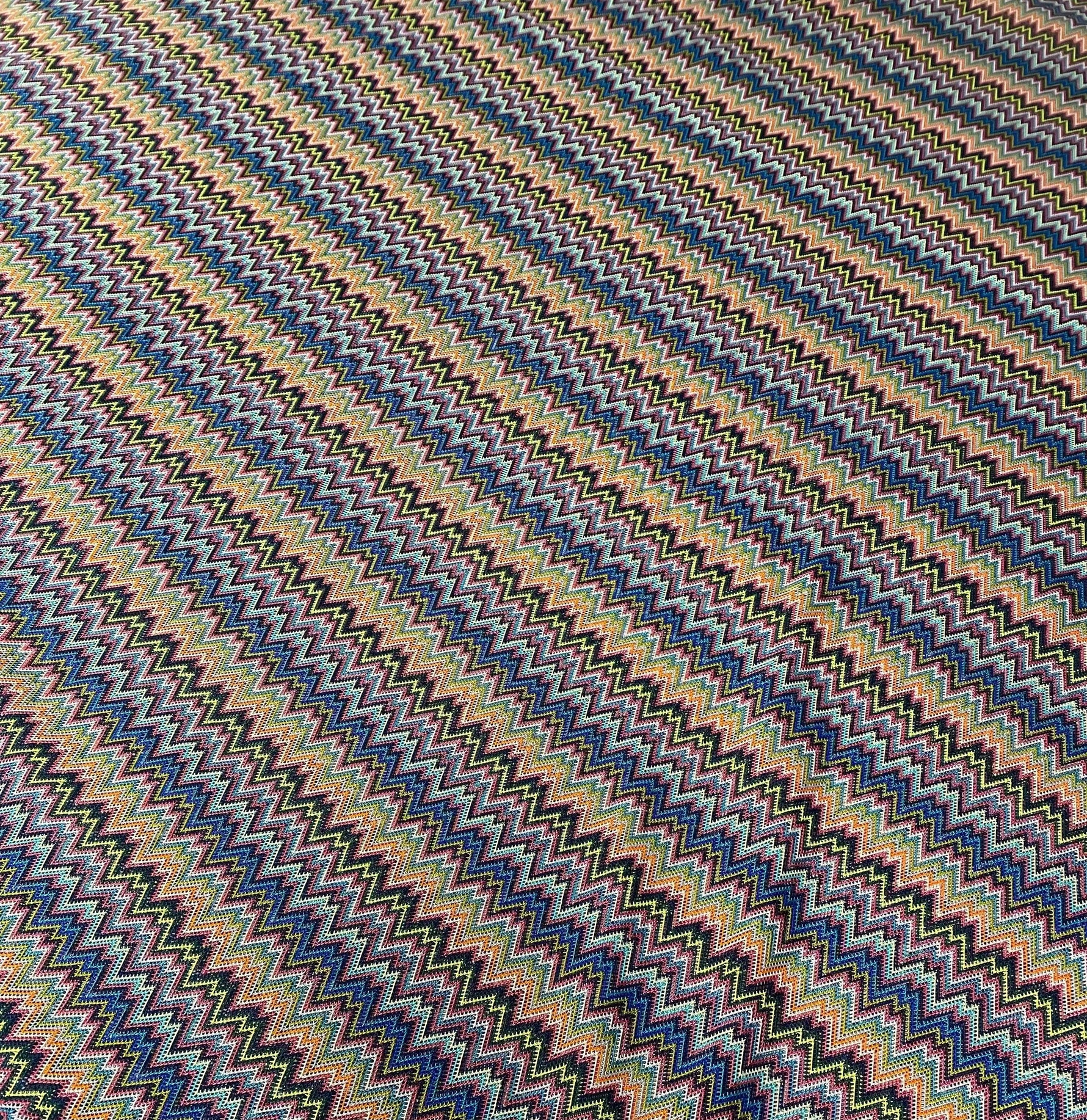 Colorful zigzag knitted mesh fabric with vibrant multicolor pattern for creative sewing projects