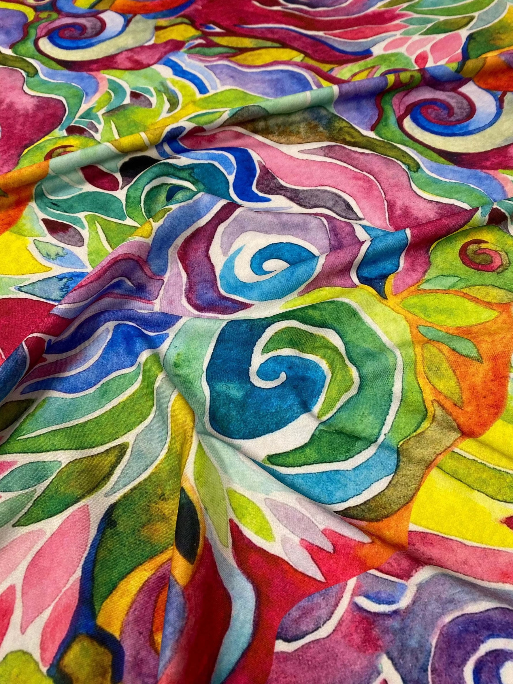 Colorful abstract floral swirl fabric with vibrant multicolor design and smooth texture