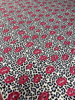 Leopard print fabric with bold black spots and pink lip pattern for upholstery and home decor projects