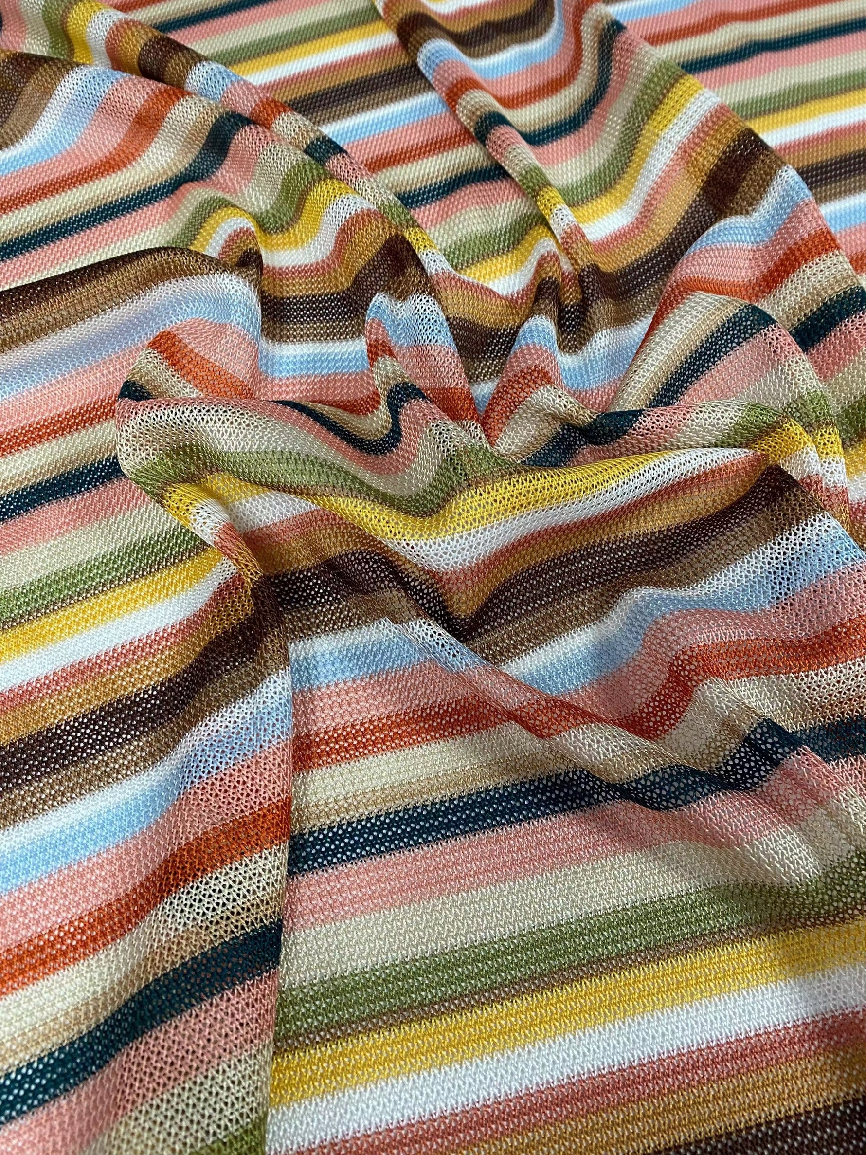Multicolor striped woven fabric with zigzag knit pattern in green tones, ideal for sewing garments like dresses, skirts, and blouses.