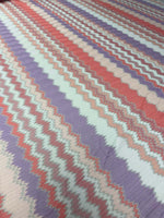 Purple and coral zigzag woven fabric with metallic accents in a continuous piece for versatile garment making
