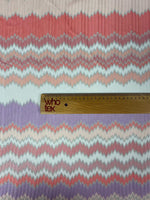 Purple and coral zigzag woven fabric with metallic accents and ruler for scale