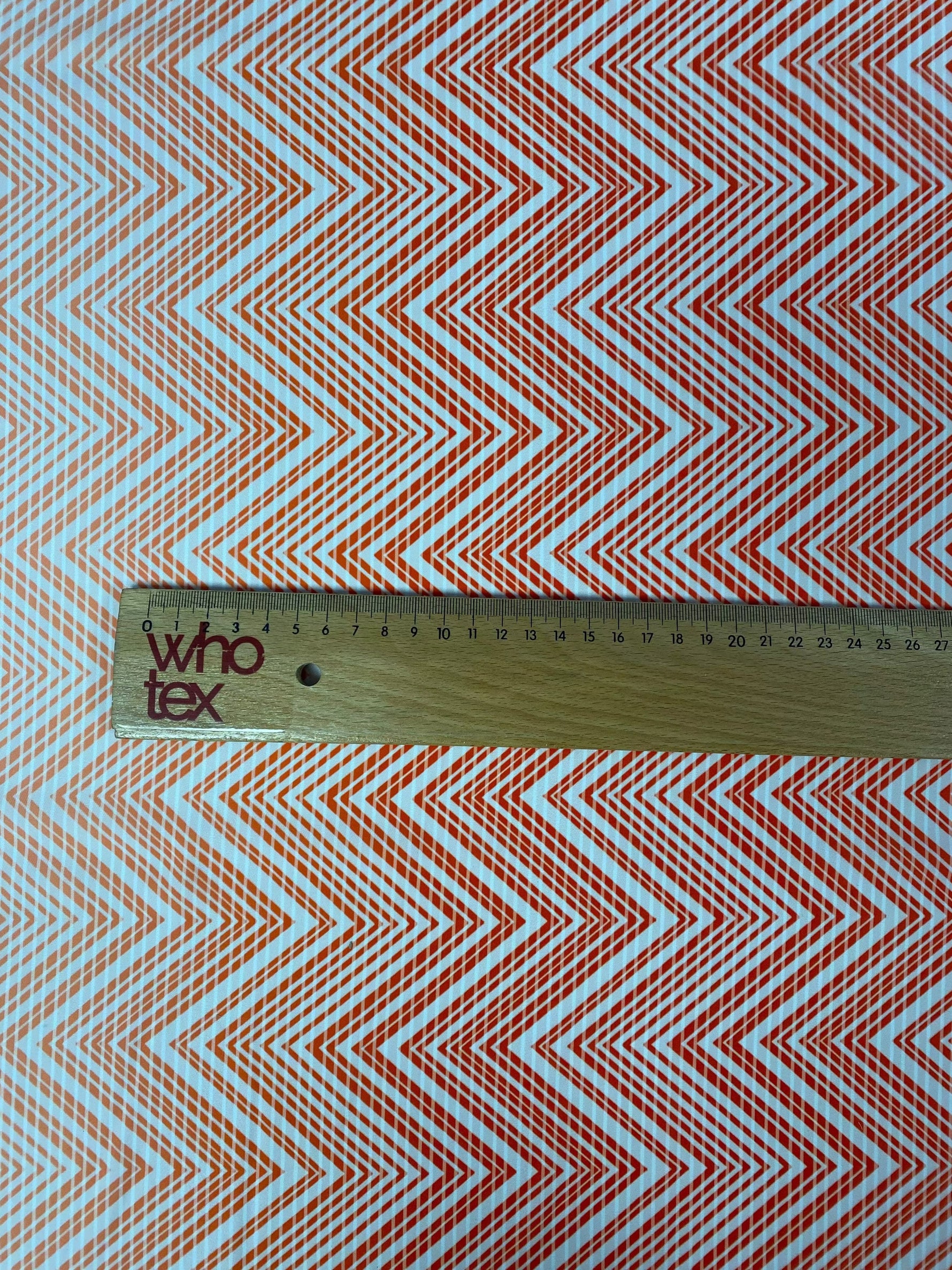 Red and white chevron fabric with ruler showing fabric width for sewing and crafting projects