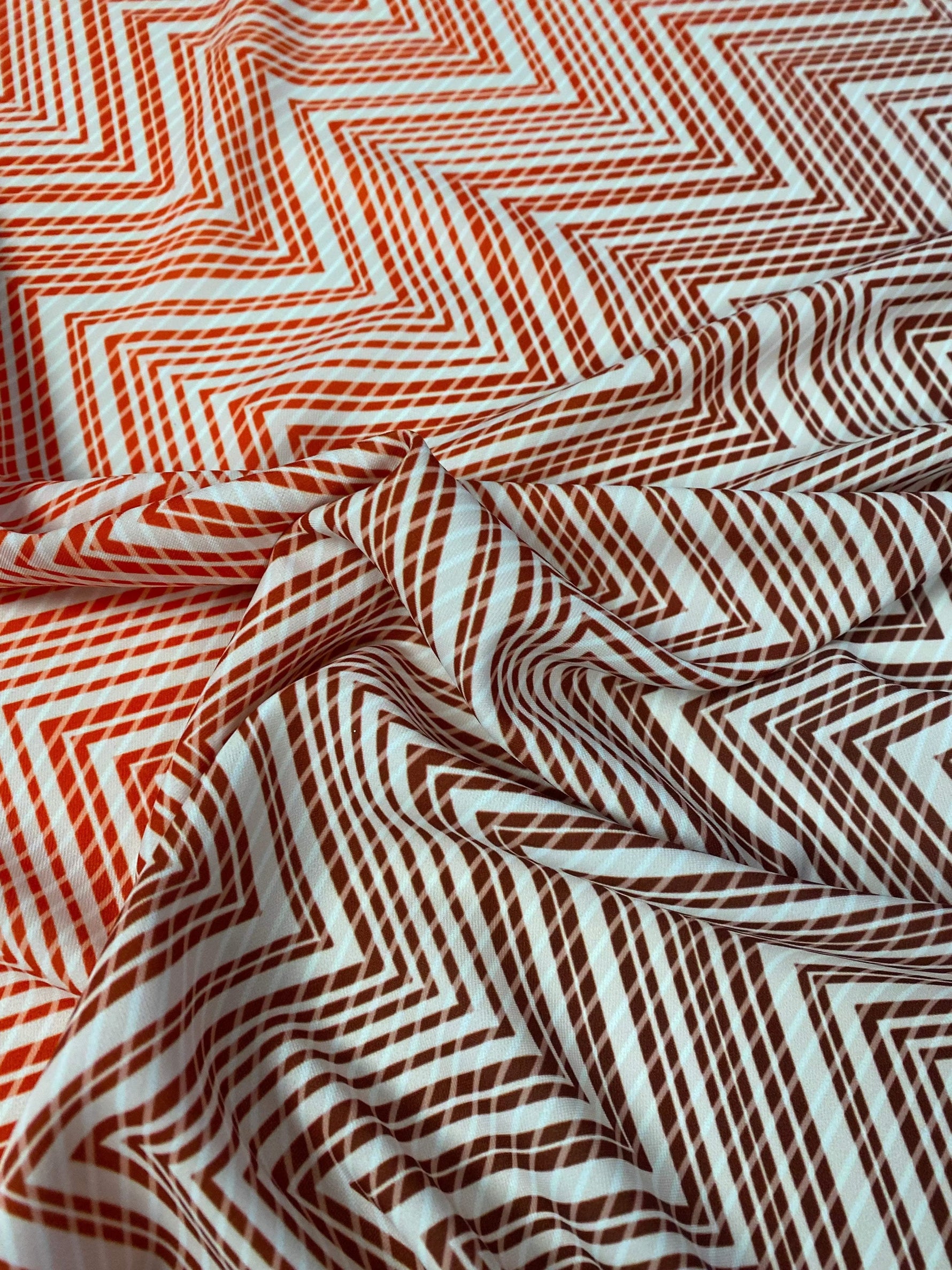 Close-up of red and white chevron patterned fabric with textured weave and 150cm width