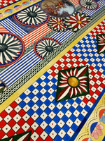 Sicilian Caretto Pattern Fabric with vibrant geometric and floral designs in red, blue, yellow, and green colors.
