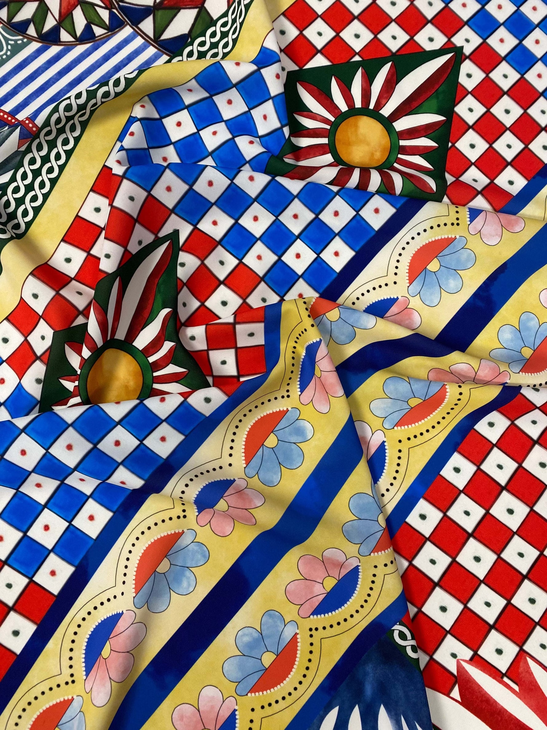 Sicilian Caretto Pattern Fabric with vibrant geometric and floral designs in red, blue, yellow, and green colors.
