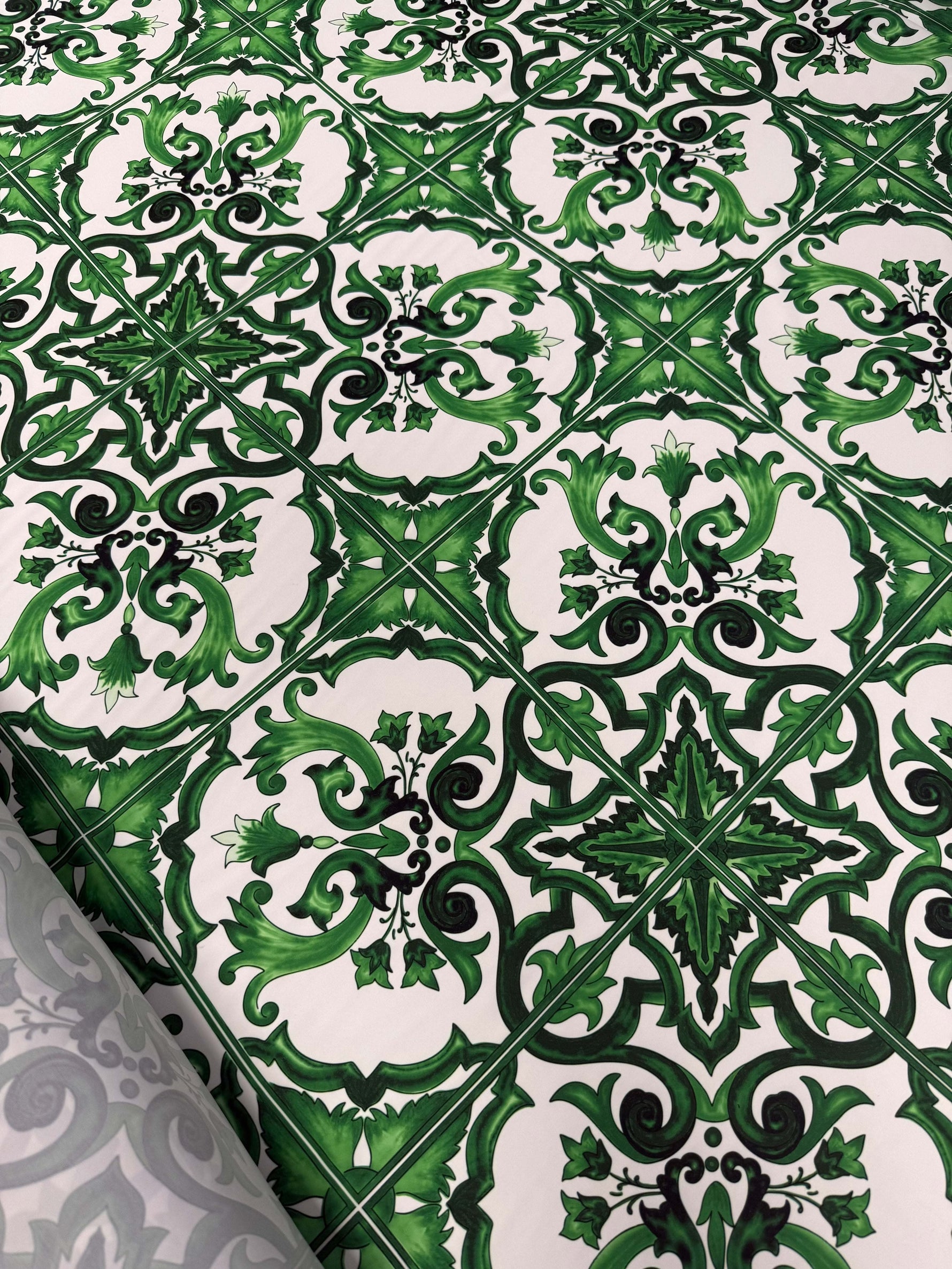 close-up of green baroque tile pattern fabric with intricate floral and geometric design