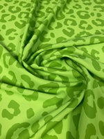 Close-up of neon green leopard print fabric with a 150cm width, folded to show texture and pattern details