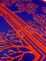 Red coral pattern on navy blue fabric panel with geometric stripes for sewing and crafts