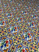 Ceramic design upholstery fabric with colorful floral tile pattern in blue, orange, green, and red on polyester material