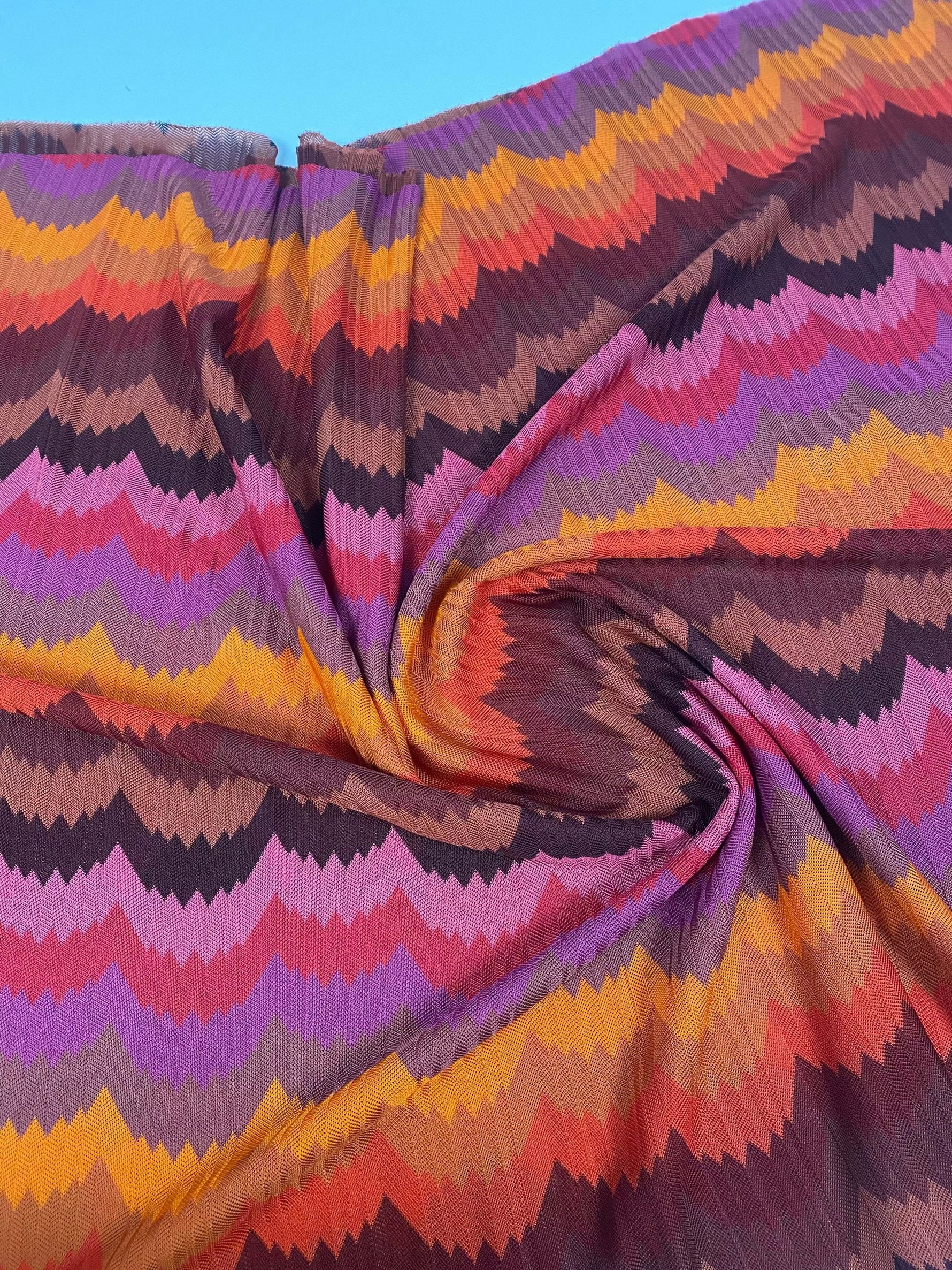 Colorful chevron zigzag mesh fabric with vibrant purple, pink, orange, and brown tones for crafting and fashion projects