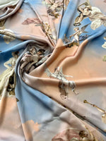 Angel print fabric in sky blue and peach tones with cherubs and clouds pattern, soft texture, 150cm wide