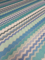 Aqua blue and mint green zigzag pattern woven knit fabric with textured stripes for fashion sewing projects