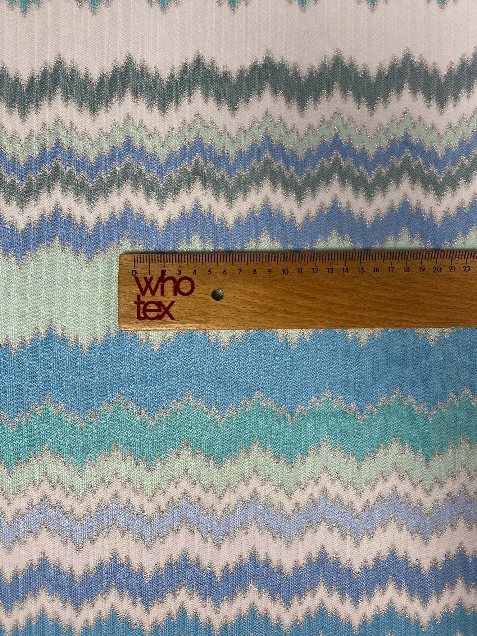 Aqua blue and mint green zigzag patterned woven fabric with ruler for scale