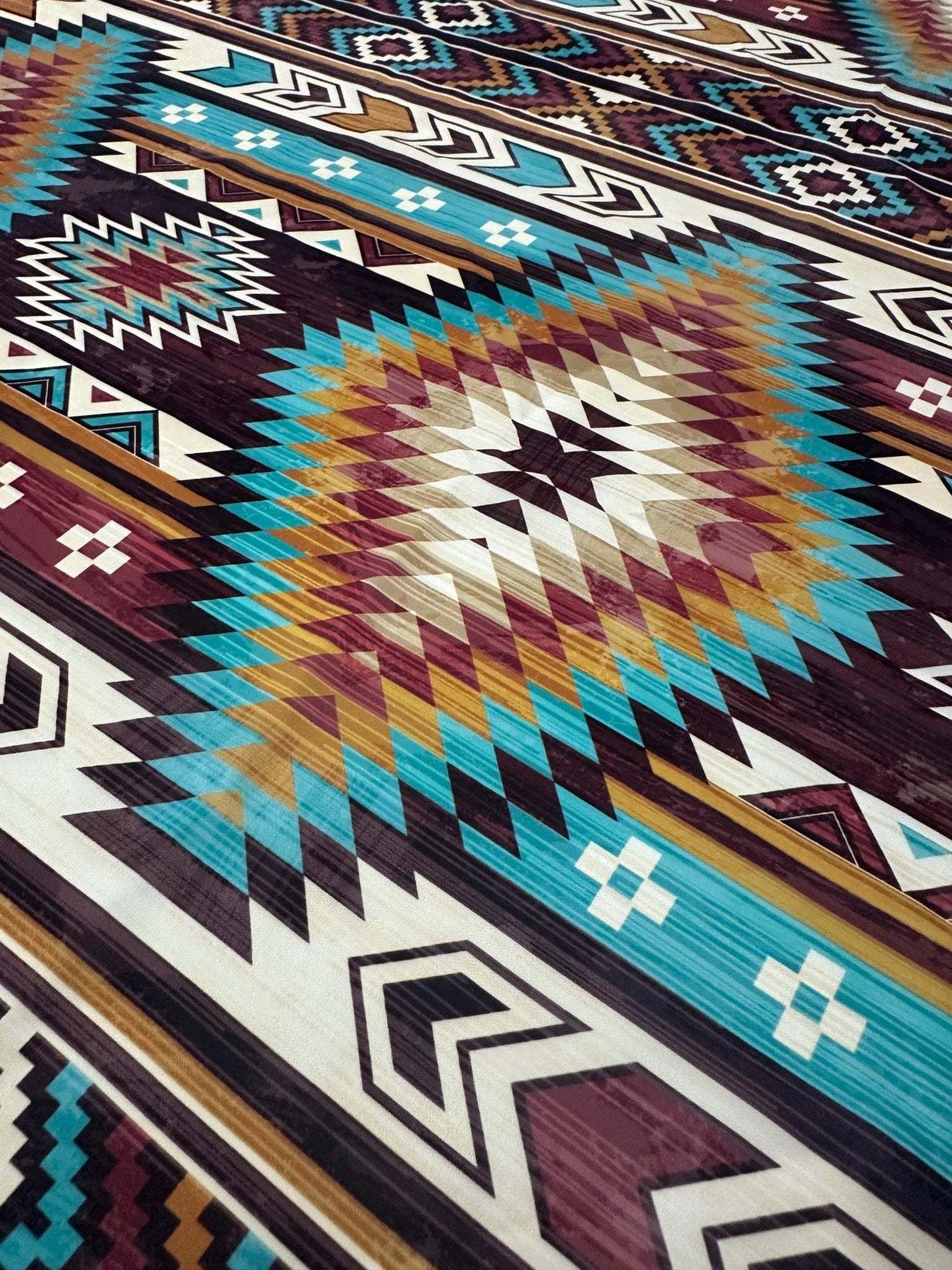 Close-up of vibrant Aztec Retro Southwest Fabric with geometric southwestern pattern in turquoise, brown, and white tones