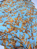 Baby blue baroque print fabric with gold ornate floral and scroll designs, soft texture, 150cm width