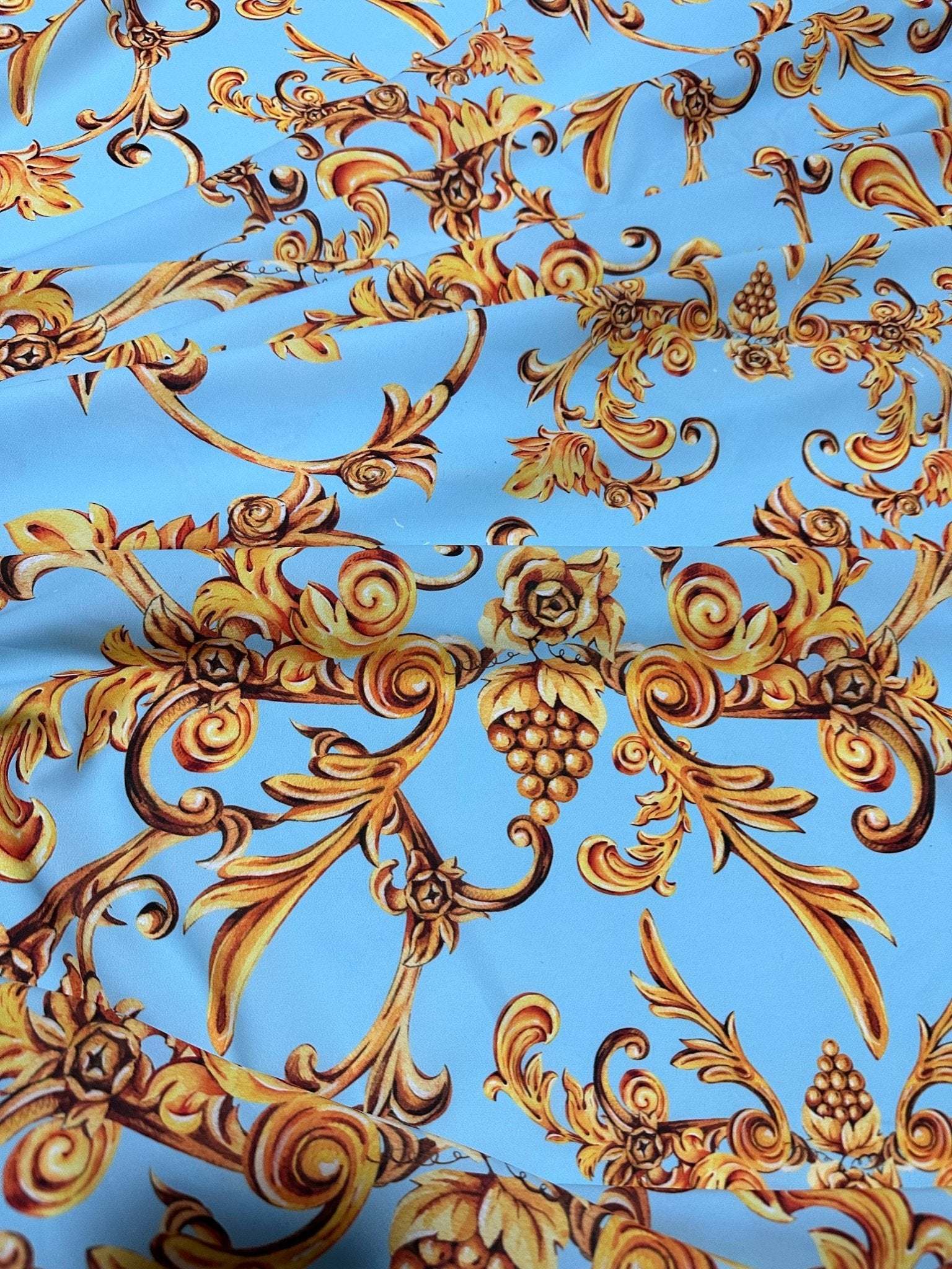 Baby blue fabric with ornate gold baroque print design suitable for sewing and home decor projects