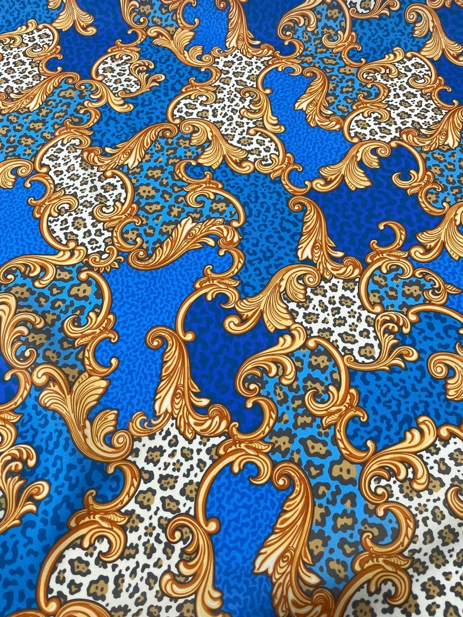 Baroque leopard print fabric with ornate gold scrolls on vibrant blue background