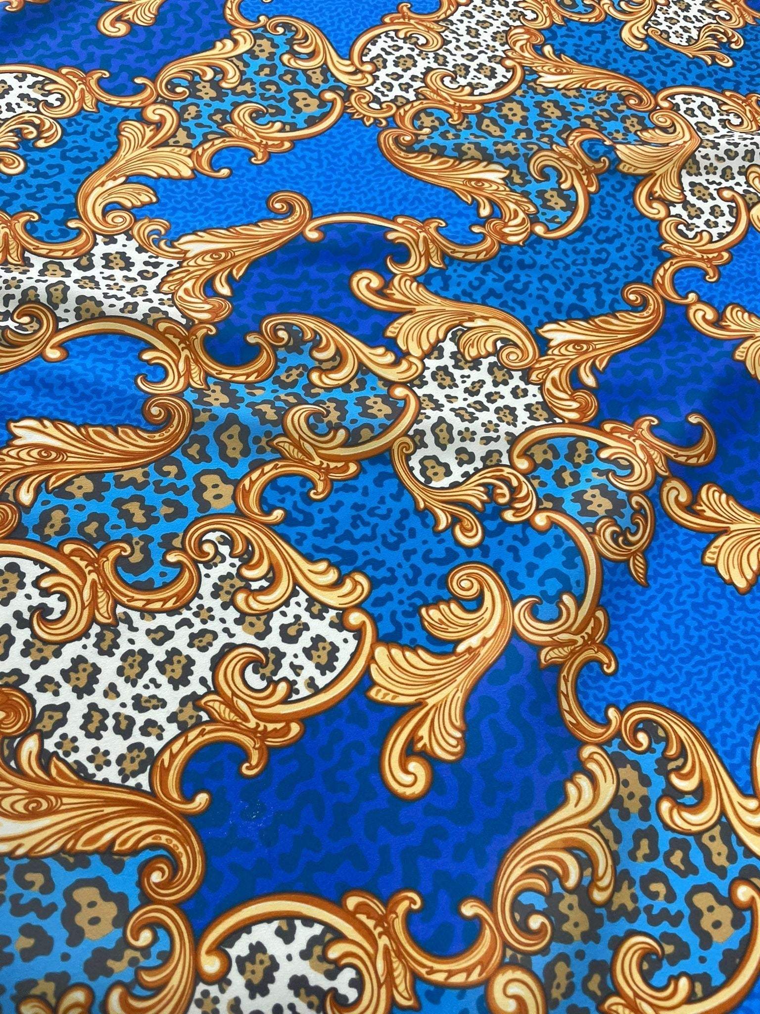 Baroque leopard print fabric with blue background and ornate gold scroll designs