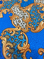 Blue Baroque leopard print fabric with gold ornate scroll patterns and animal spots design