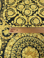 Baroque black and gold upholstery fabric with ornate floral and scroll patterns and a measuring ruler for scale