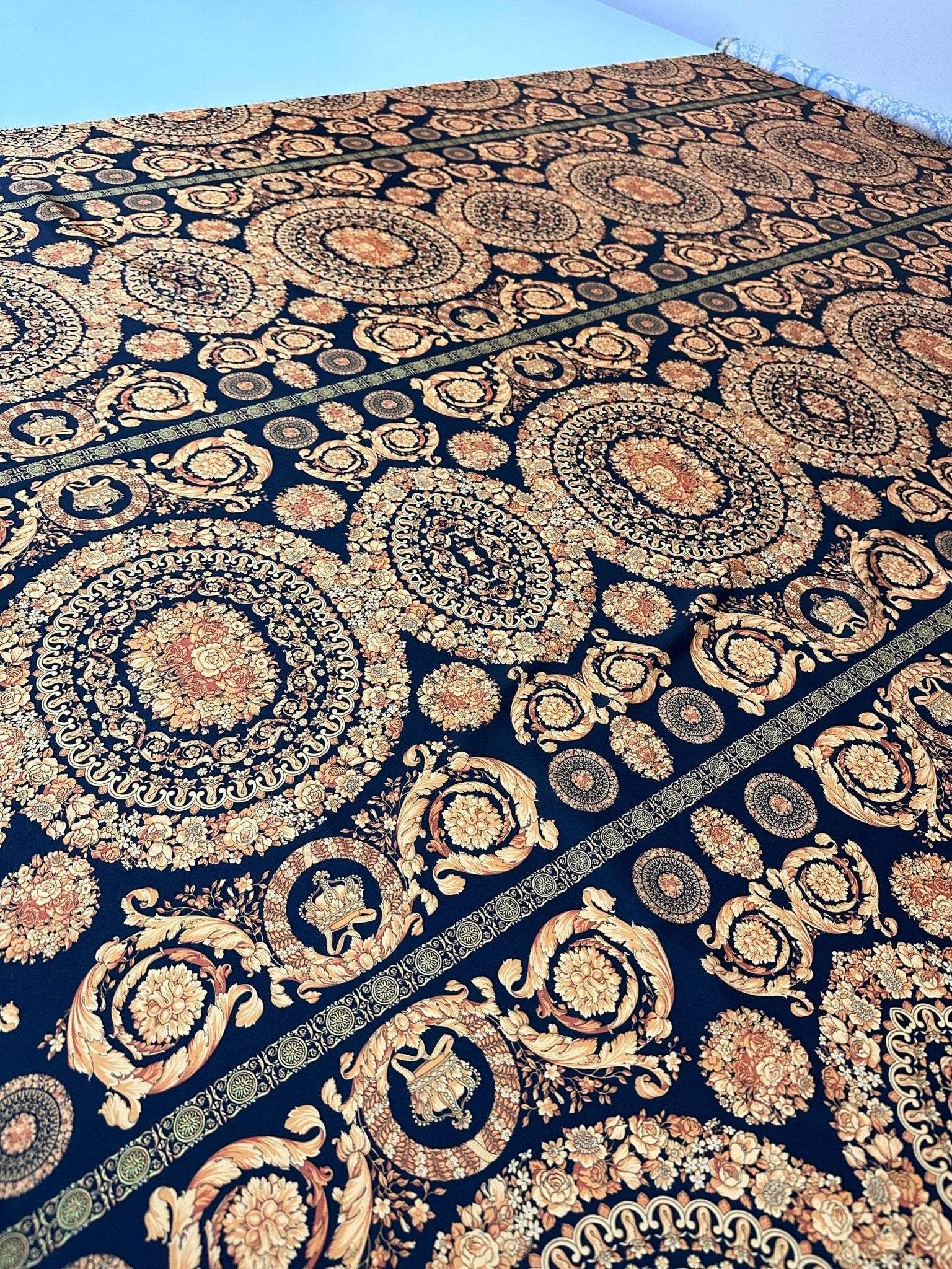 Baroque black and gold fabric with intricate circular and floral patterns for upholstery and fashion projects
