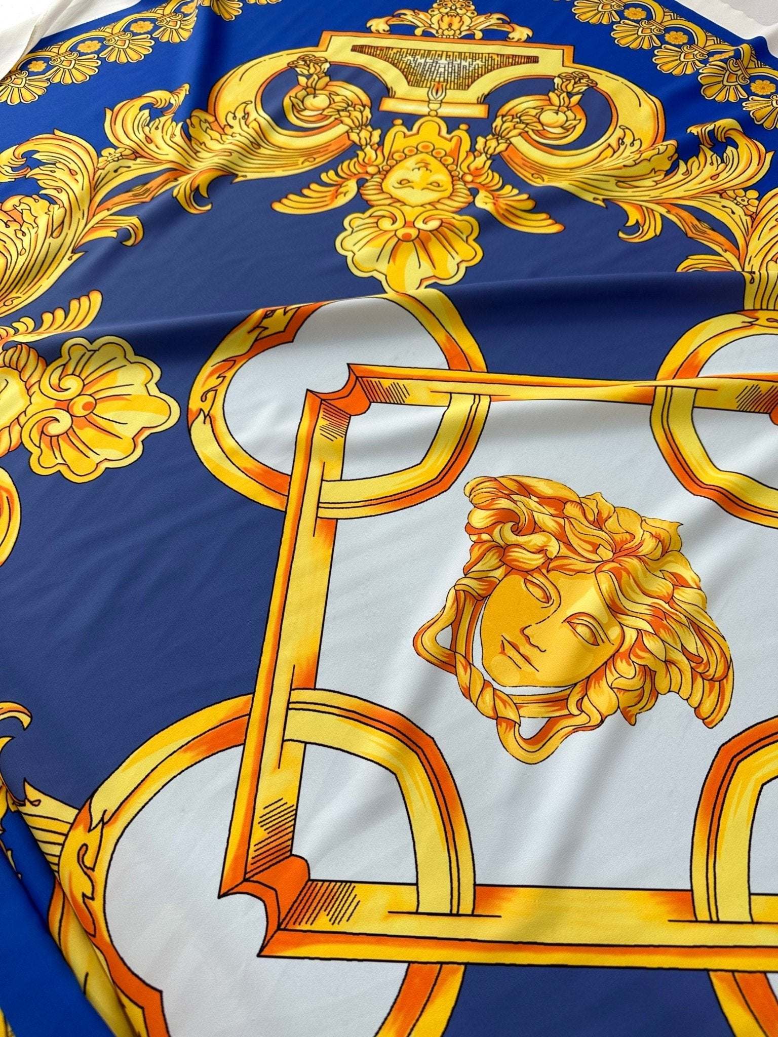 Baroque gold pattern fabric on royal blue background with ornate gold designs and classical motifs