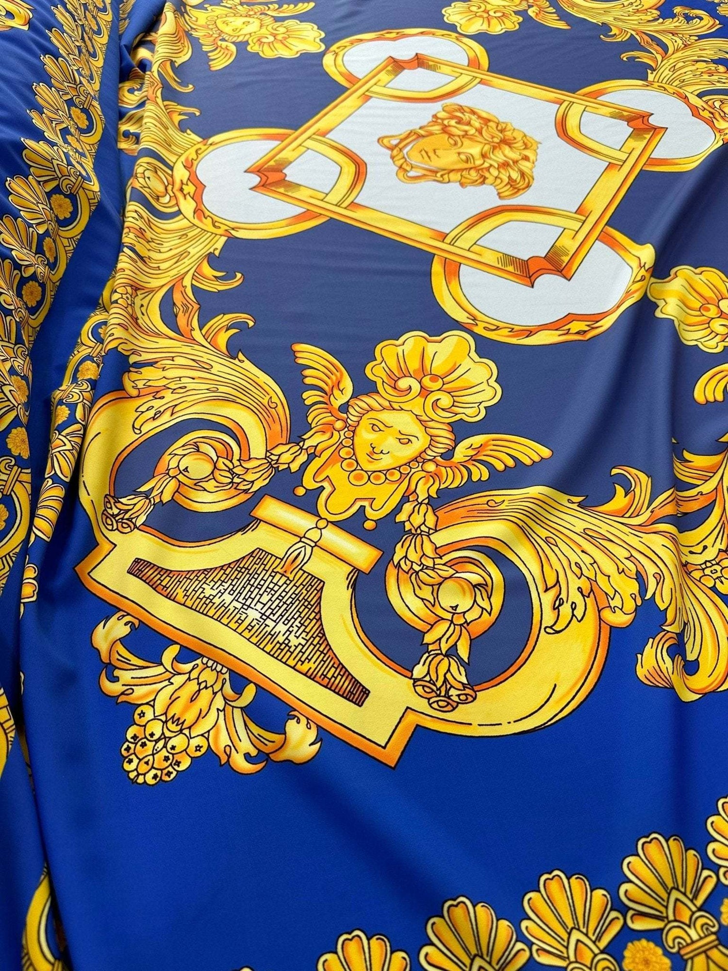 Baroque gold pattern fabric on royal blue background with intricate ornate designs for upholstery and drapery