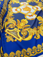 Baroque gold pattern fabric with intricate designs on royal blue background, ideal for upholstery and drapery.