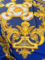 Baroque gold pattern fabric with intricate designs on royal blue background, ideal for upholstery and drapery.