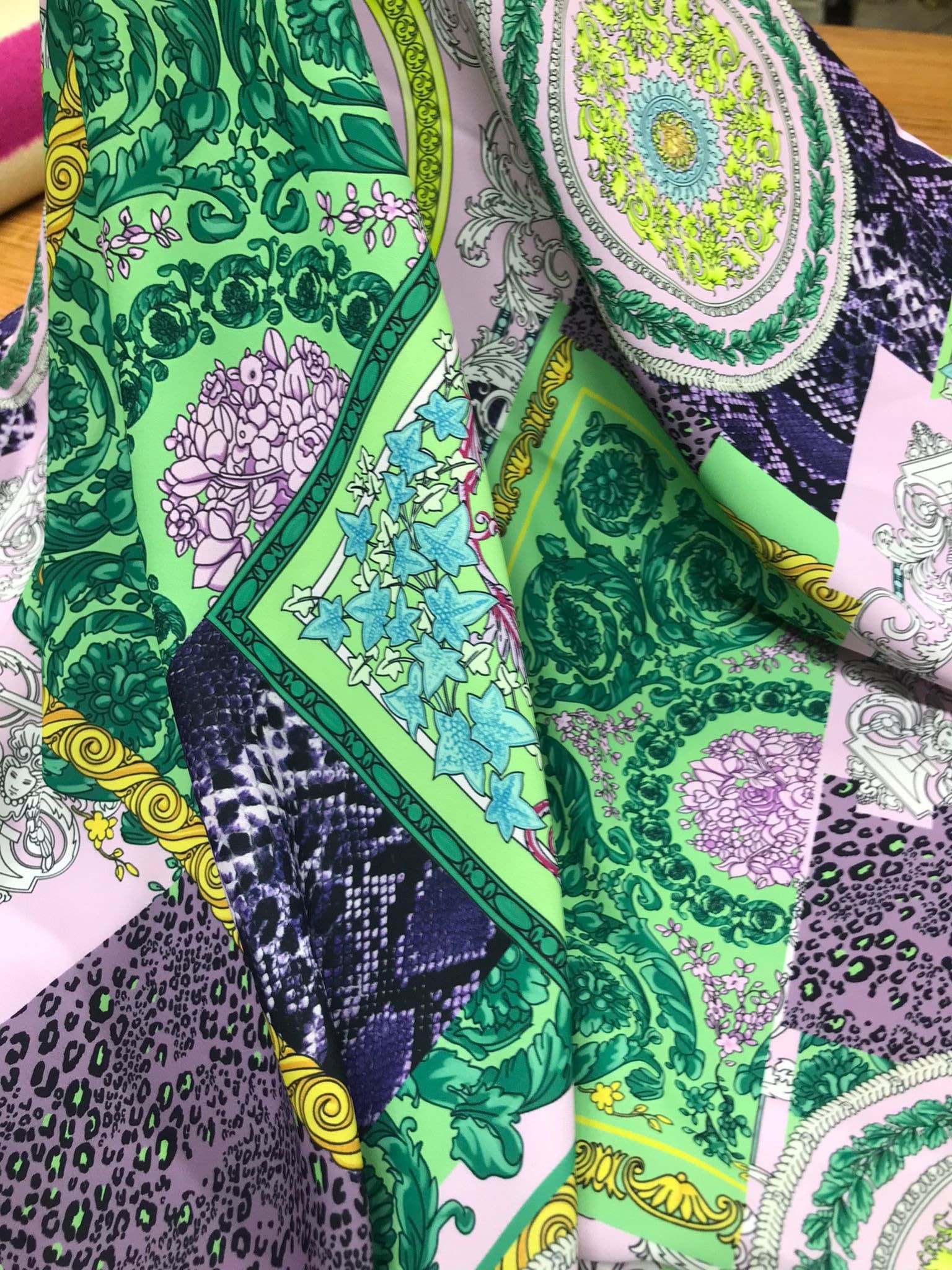 Baroque pattern fabric with green borders and soft pastel colors featuring intricate floral and ornamental designs