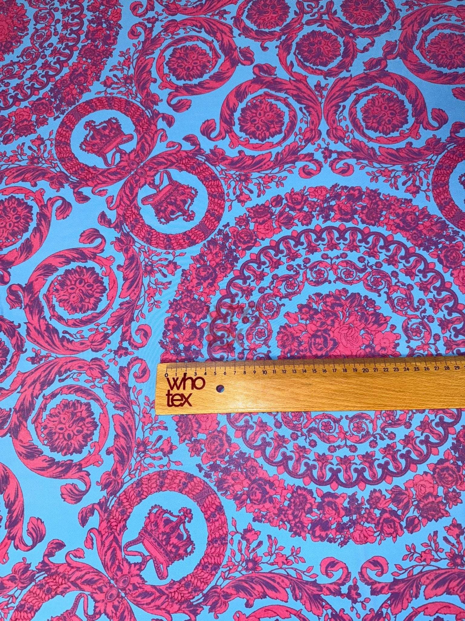 Purple and blue Baroque pattern fabric with intricate circular designs and a ruler for scale on 150cm wide material