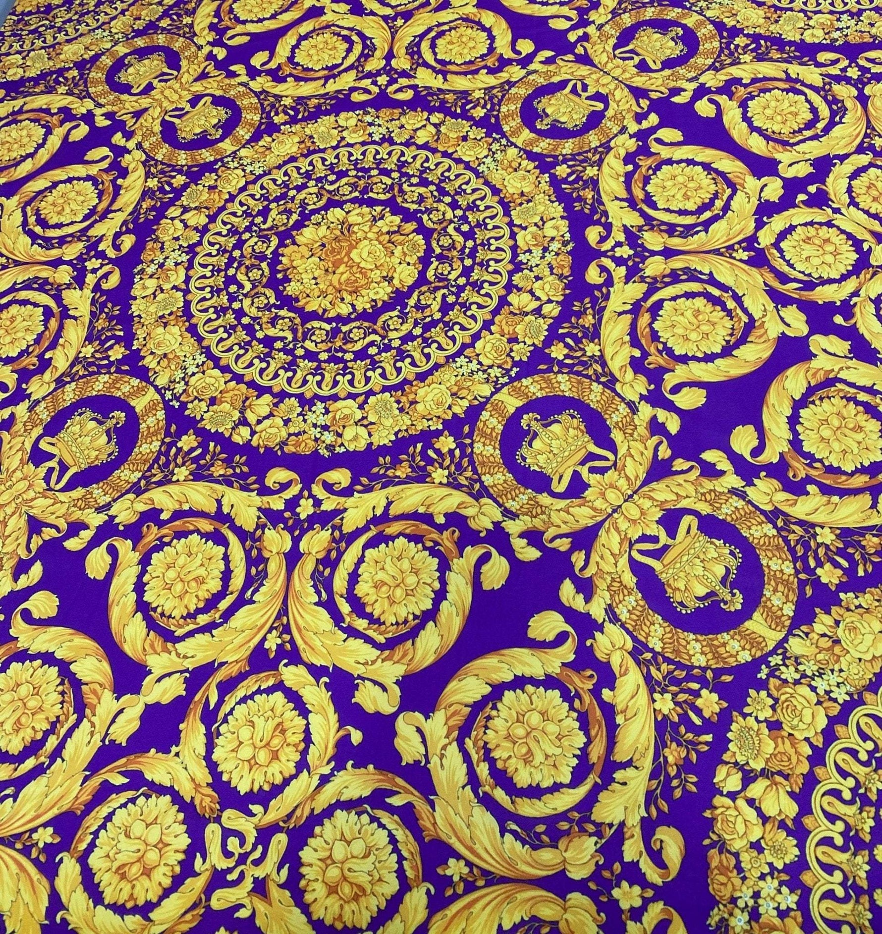 Purple Baroque pattern fabric with intricate gold floral and ornamental designs on a rich purple background, suitable for upholstery and drapery.