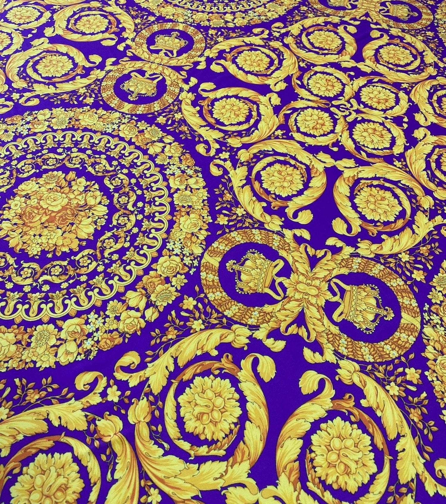 Purple Baroque Pattern Fabric with intricate gold floral and ornamental designs on a rich purple background, ideal for upholstery and drapery.