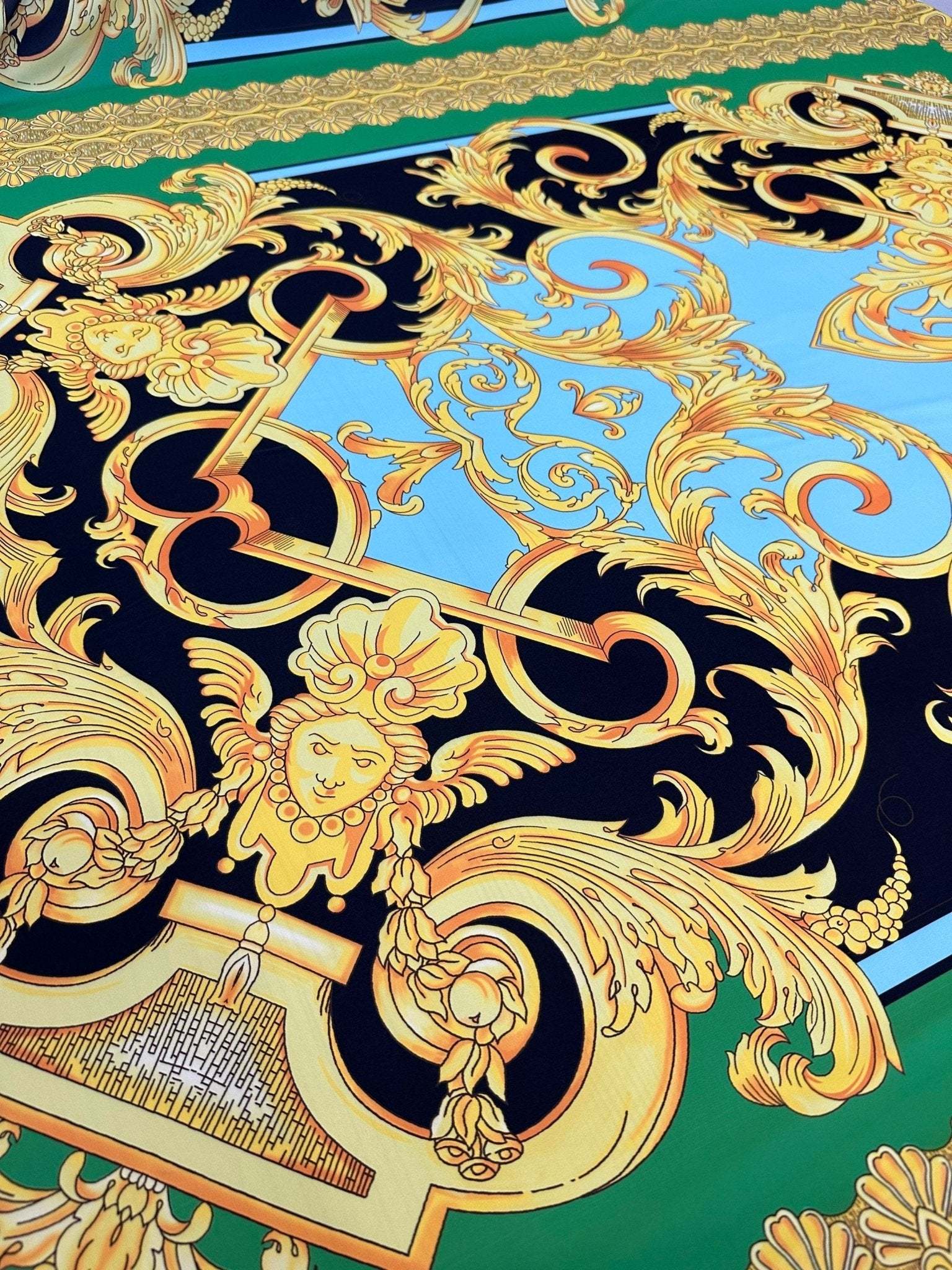 Baroque Silky Crepe Fabric with intricate gold baroque patterns on green, blue, and black background