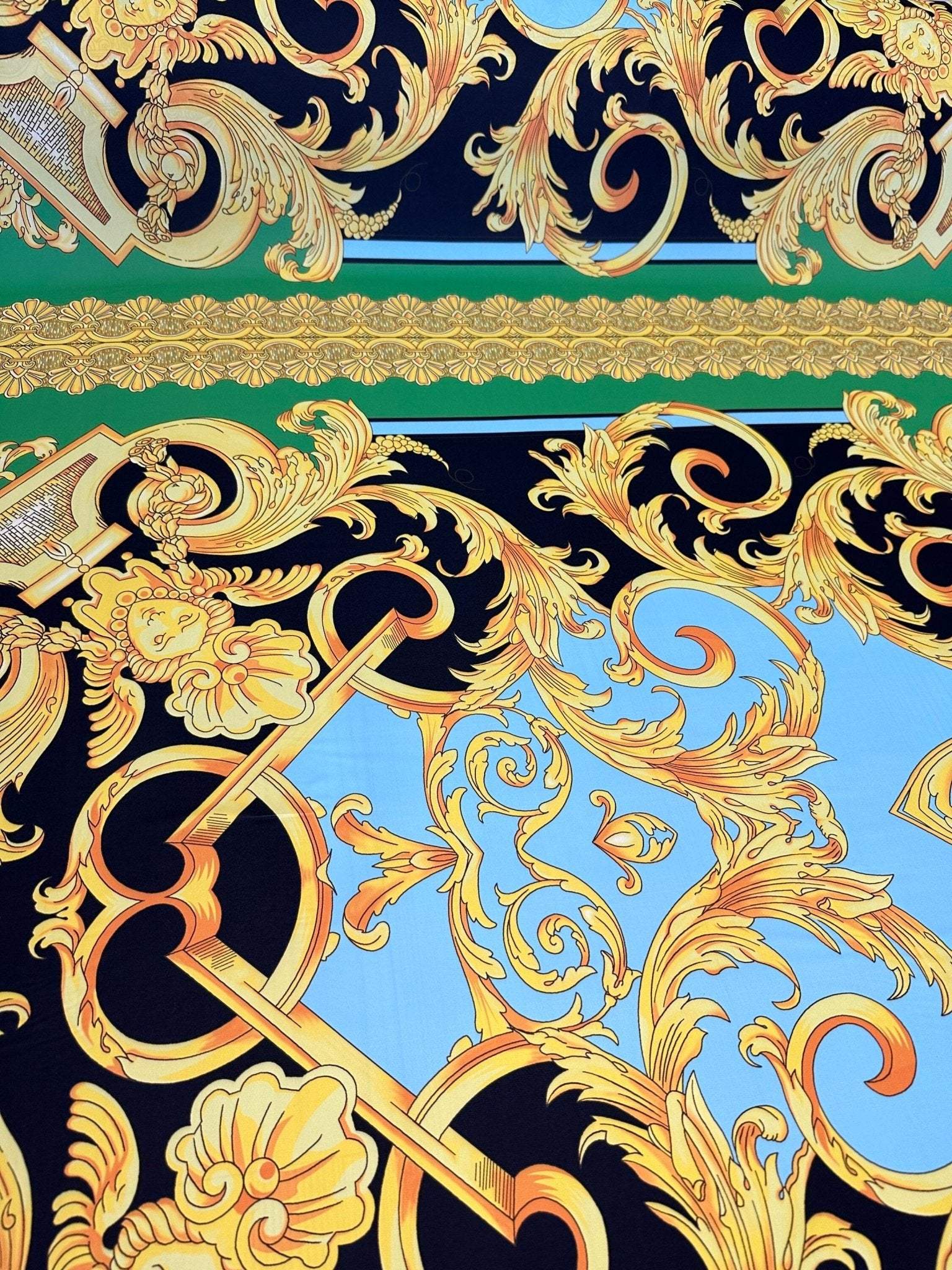Baroque silky crepe fabric with intricate gold patterns on black, blue, and green background