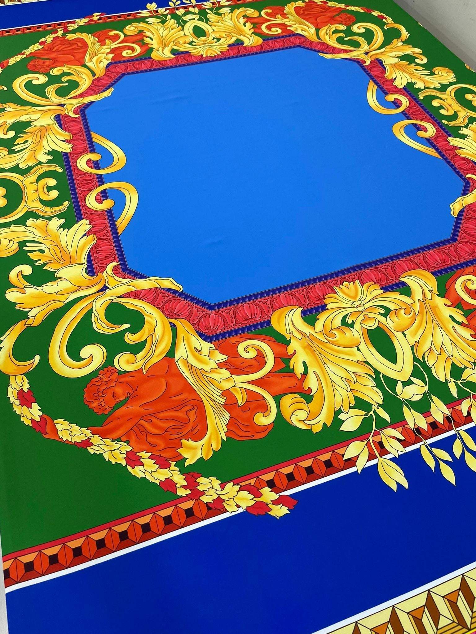 Baroque Silky Crepe Fabric with vibrant blue center and intricate gold and red baroque patterns on green background