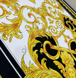 Baroque silky crepe fabric with elegant gold and black ornate pattern on white background