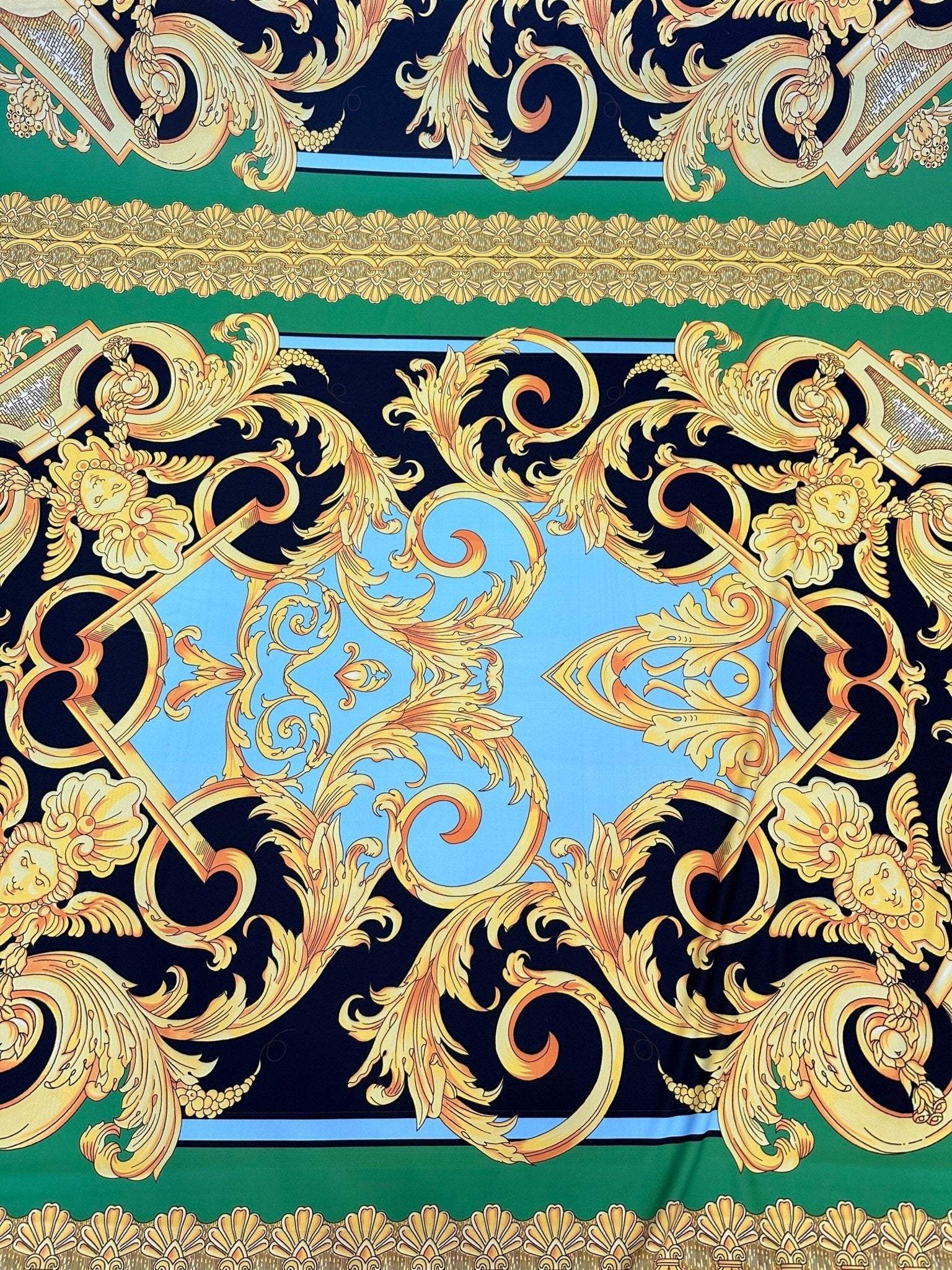 Baroque silky crepe fabric with intricate gold baroque patterns on blue, green, and black background