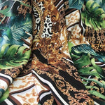 Baroque Tropical Green fabric with gold ornate designs and lush green tropical leaves on black and white background