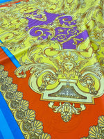 Baroque pattern silky crepe fabric in vibrant orange and blue with intricate gold details and a smooth, luxurious texture