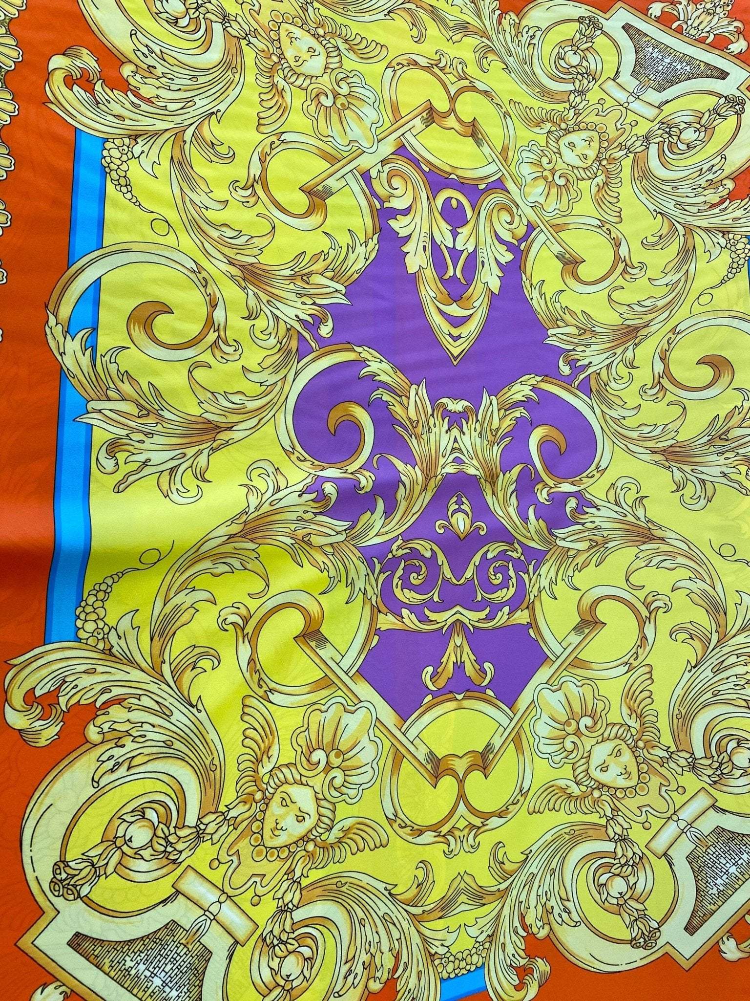 Baroque pattern silky crepe fabric in vibrant orange, blue, yellow, and purple with intricate golden design details
