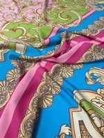 Baroque pink silky crepe fabric with ornate gold and green baroque patterns on blue background